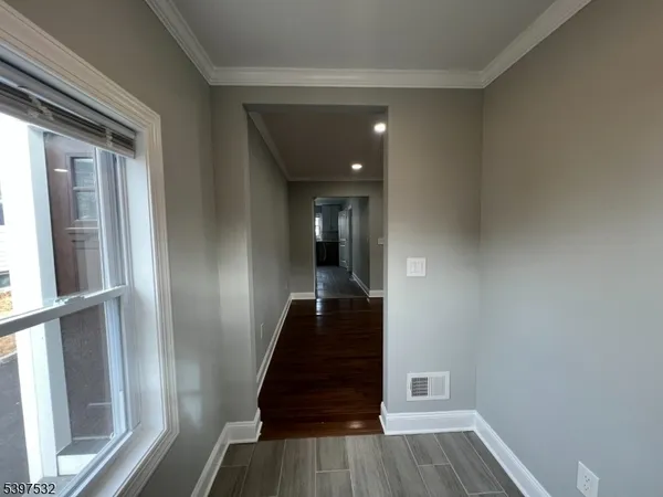 a view of a hallway with wooden floor and staircase