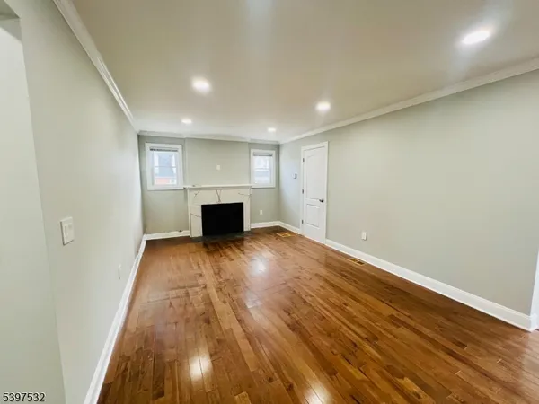 an empty room with wooden floor and fireplace