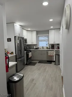 a kitchen with stainless steel appliances granite countertop a refrigerator sink and stove