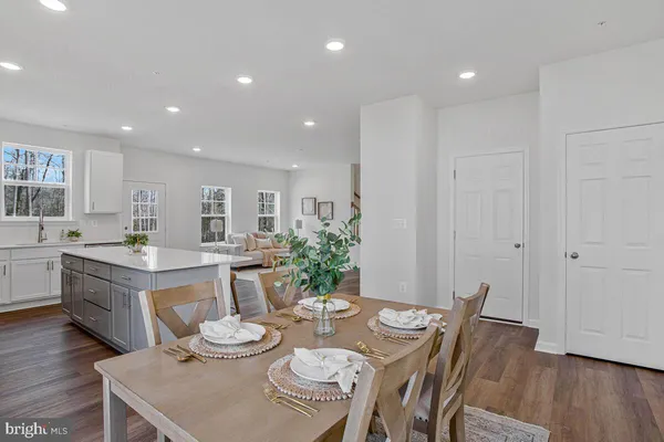 a living room with furniture and kitchen view with wooden floor