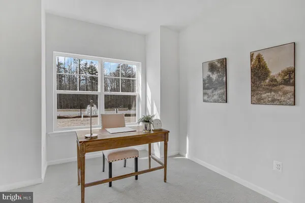 a view of a dining room with furniture a rug and wooden floor