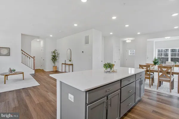 a living room with stainless steel appliances kitchen island granite countertop a sink and cabinets