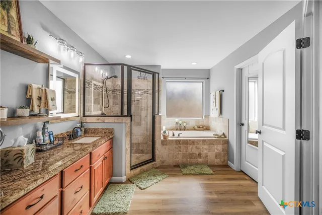 a spacious bathroom with a granite countertop sink mirror and shower
