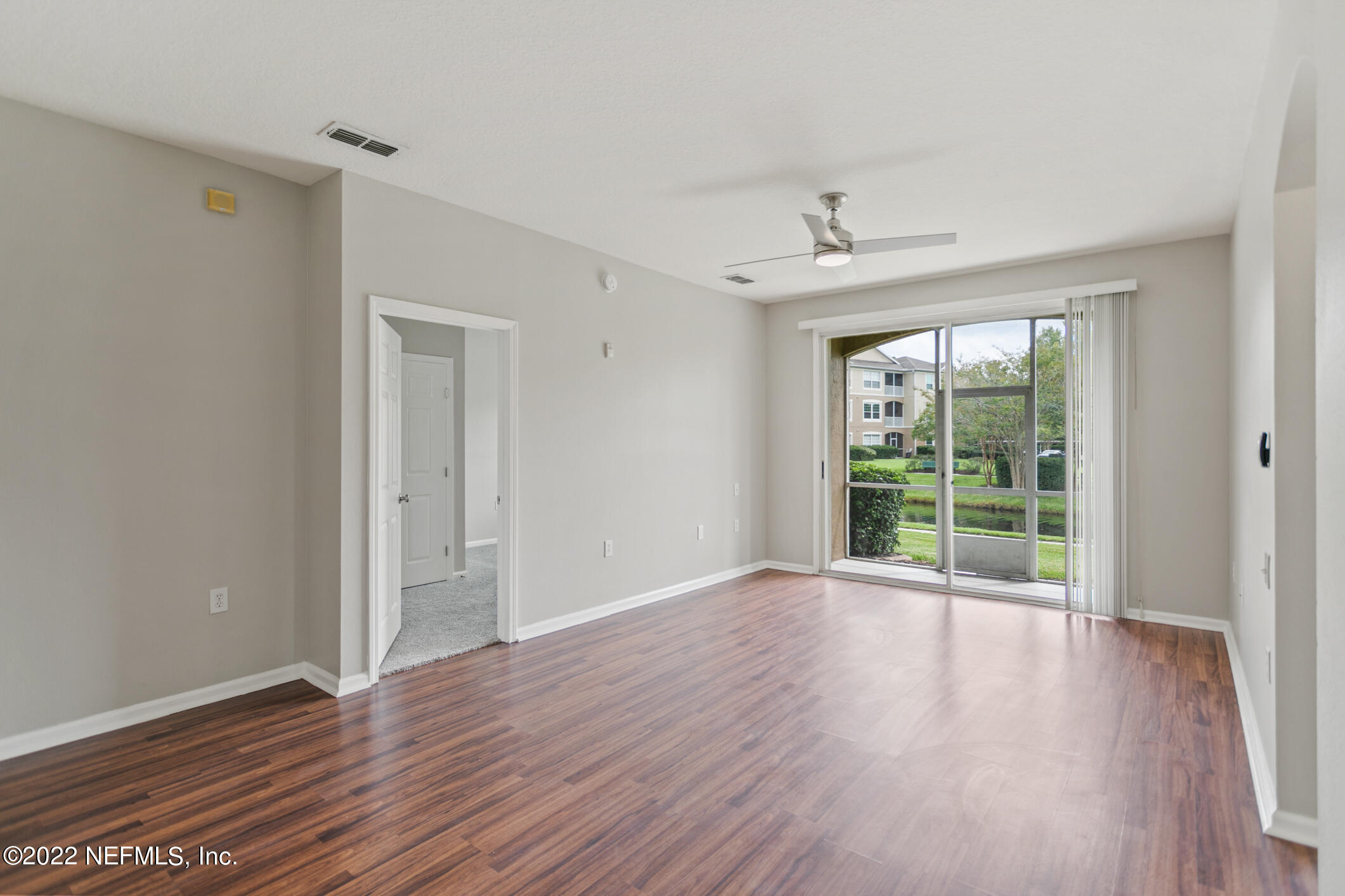 7990 Baymeadows Road, Unit 303 Jacksonville, FL 32256 - Photo 8 of 40 a view of an empty room with wooden floor and a window