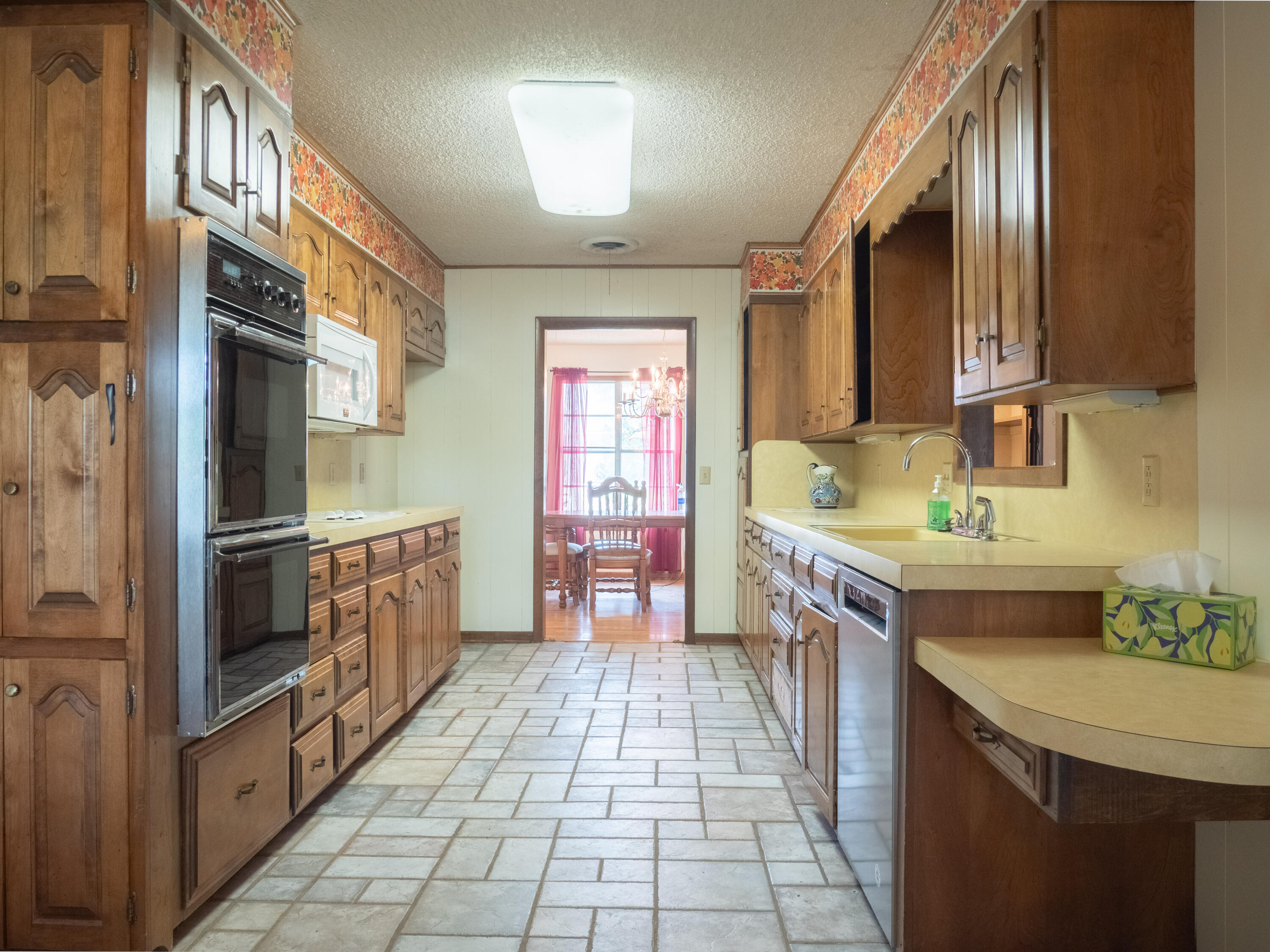 303 Comanche Trail Tulia, TX 79088 - Photo 11 of 37 a kitchen with granite countertop a sink stove and cabinets