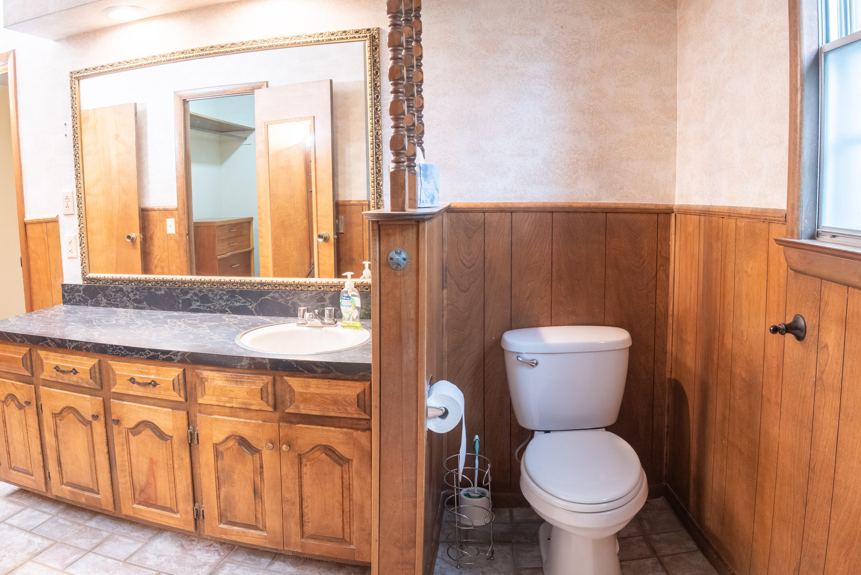 303 Comanche Trail Tulia, TX 79088 - Photo 27 of 37 a bathroom with a granite countertop toilet a sink and a mirror