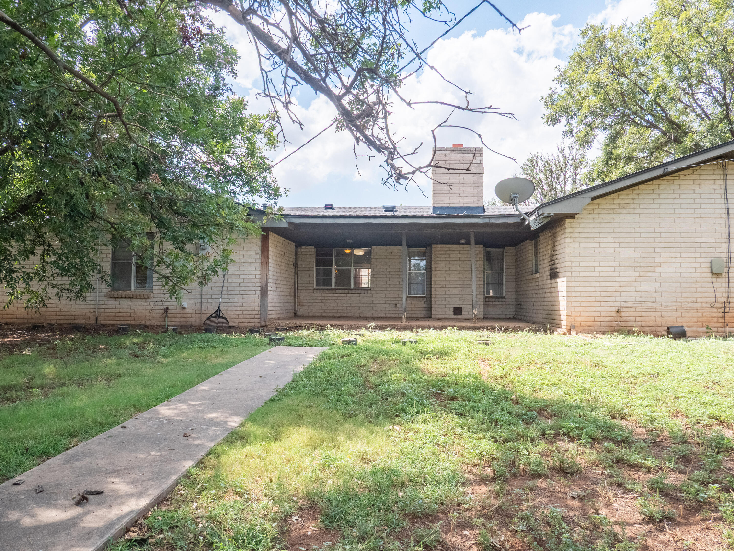 303 Comanche Trail Tulia, TX 79088 - Photo 35 of 37 a front view of a house with a garden and trees