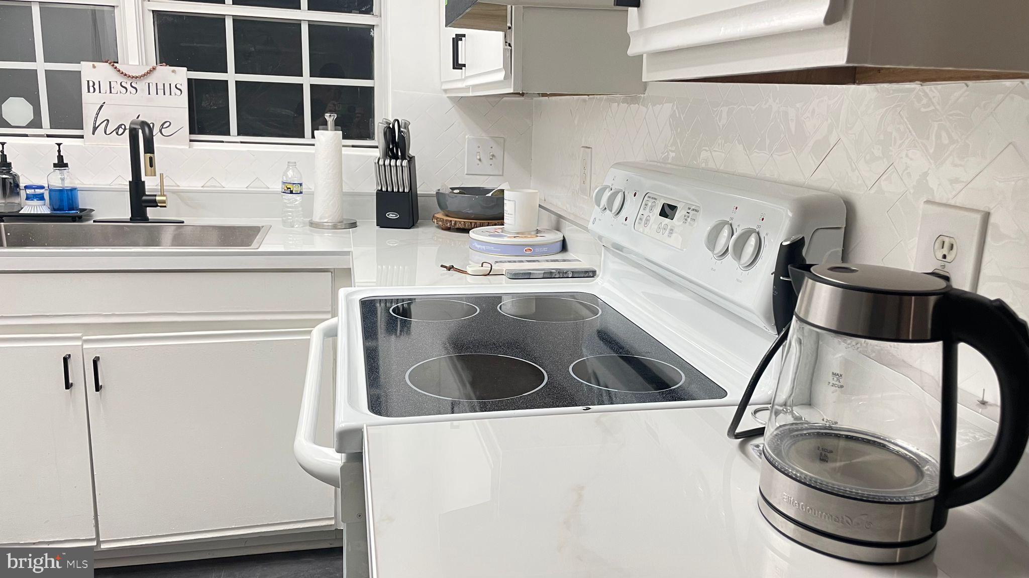 124 Fort Evans Road Southeast, Unit C Leesburg, VA 20175 - Photo 16 of 21 a kitchen with a stove and a white cabinet
