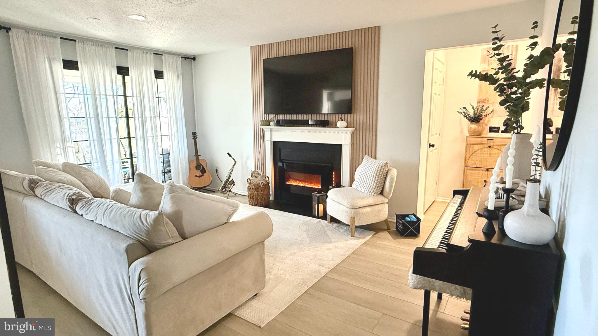 124 Fort Evans Road Southeast, Unit C Leesburg, VA 20175 - Photo 2 of 21 a living room with furniture a flat screen tv and a fireplace