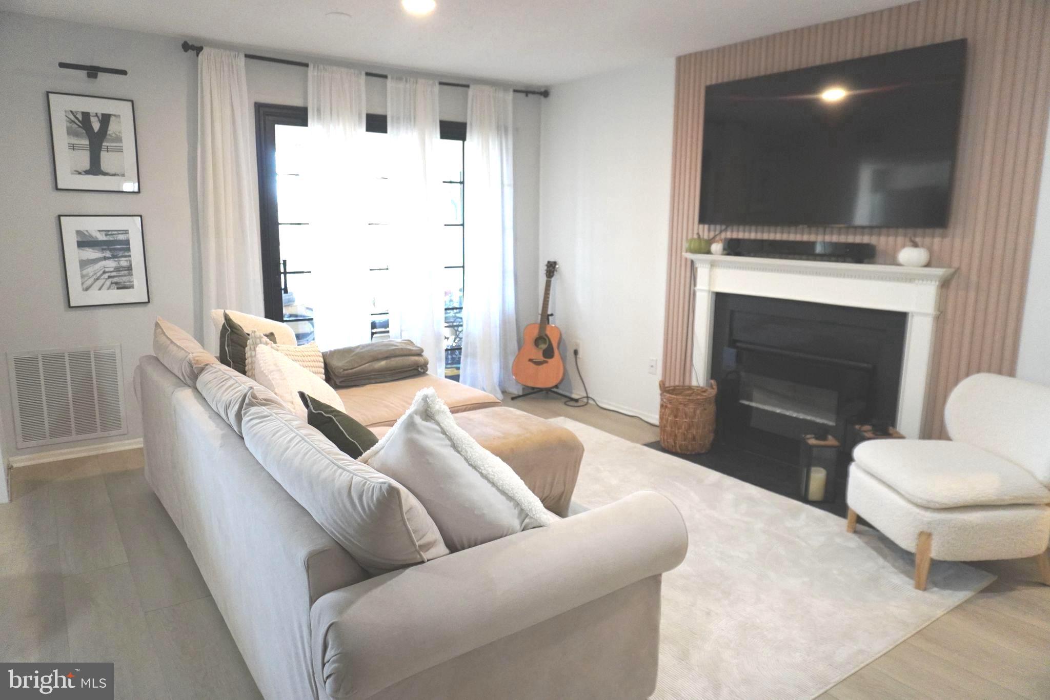 124 Fort Evans Road Southeast, Unit C Leesburg, VA 20175 - Photo 3 of 21 a living room with furniture a flat screen tv and a fireplace