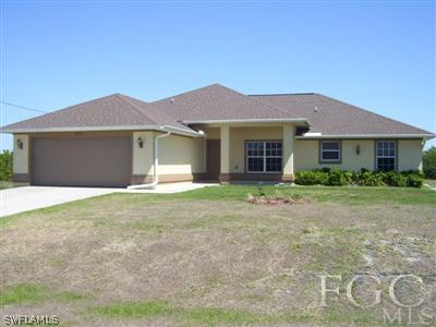 3204 35th Street Southwest Lehigh Acres, FL 33976 - Photo 1 of 3 a front view of a house with a garden