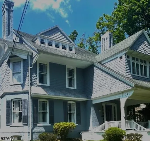 a front view of a house with plants