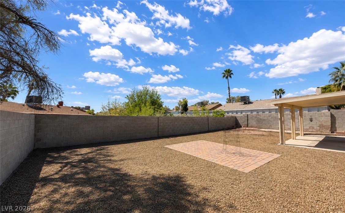6491 West Viking Road Las Vegas, NV 89103 - Photo 5 of 5 A spacious, gravel-filled backyard offers ample room for outdoor activities, complemented by a covered patio.