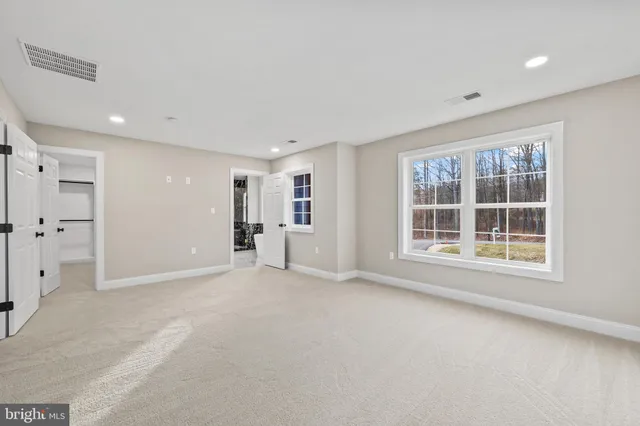 a spacious bathroom with a tub a sink and mirror