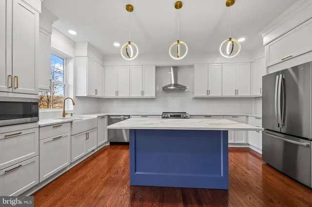 a kitchen with cabinets wooden floor and stainless steel appliances
