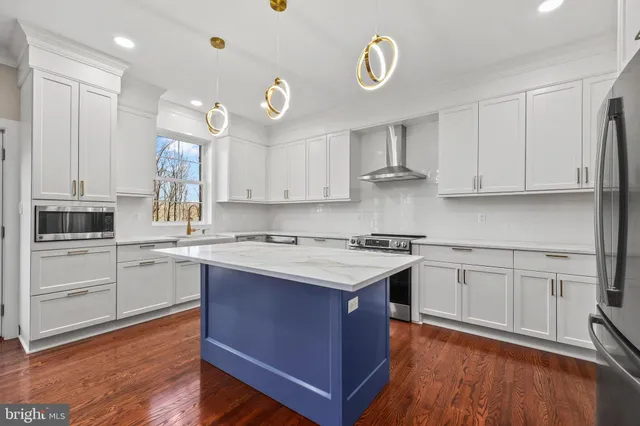 a large kitchen with kitchen island a sink stainless steel appliances and cabinets