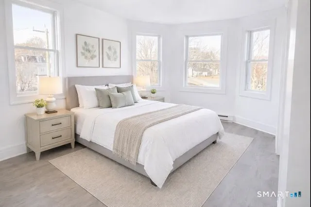 a large bed sitting in a bedroom next to a window