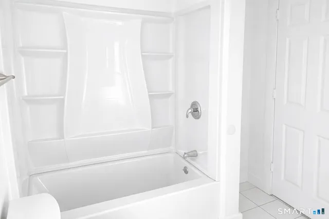 a white bath tub sitting next to a white toilet