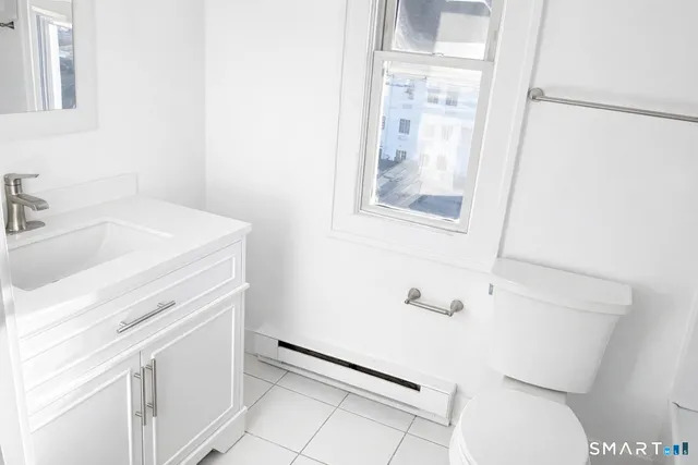 a bathroom with a sink a toilet and a mirror