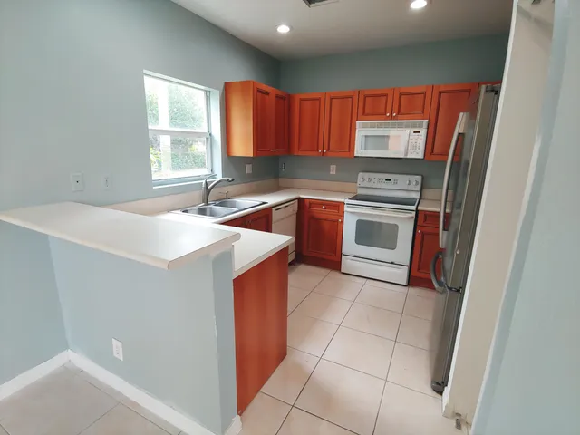 a kitchen with stainless steel appliances a stove a sink and a microwave