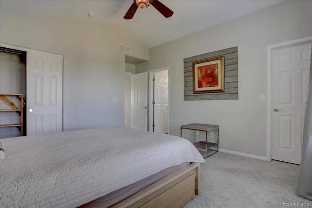 a bedroom with a bed and painting on the wall