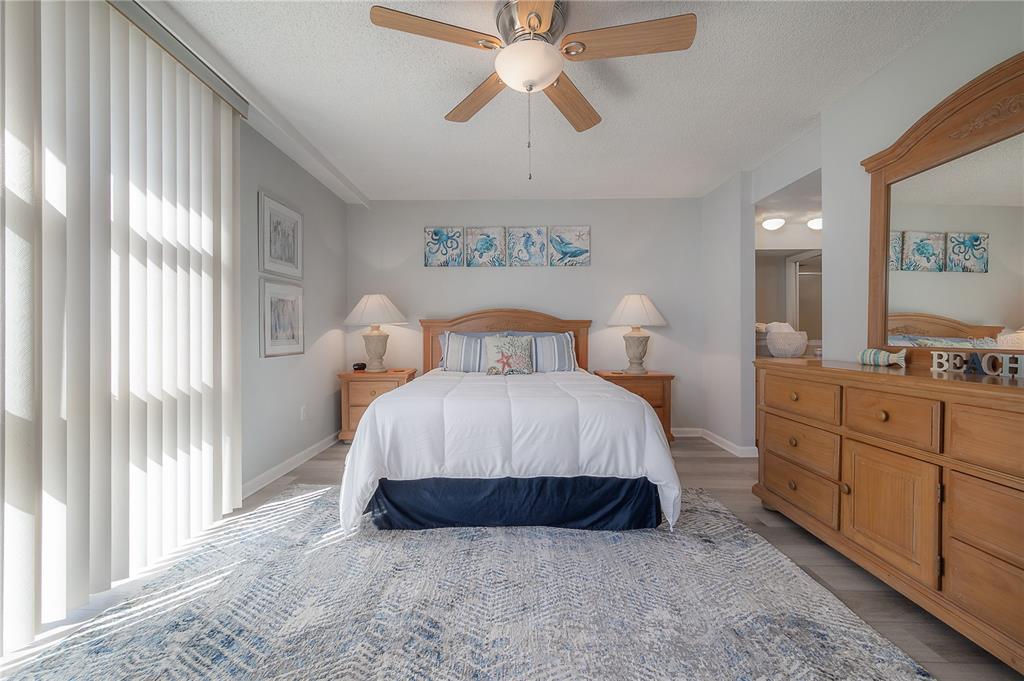 16308 Gulf Boulevard, Unit 209 Redington Beach, FL 33708 - Photo 20 of 54 a spacious bedroom with a bed and a chandelier