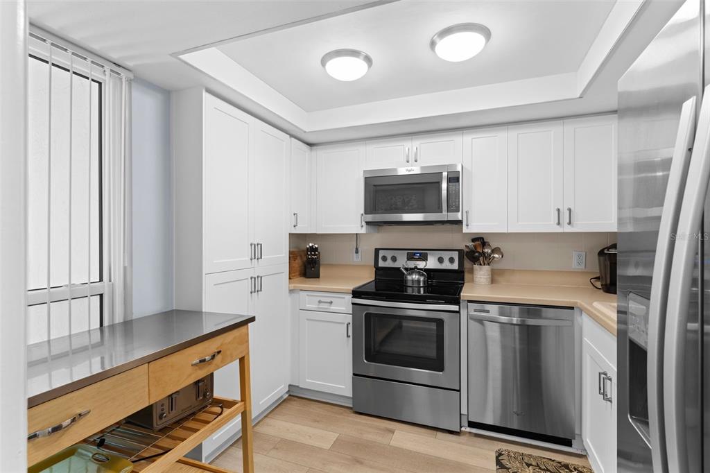 16308 Gulf Boulevard, Unit 209 Redington Beach, FL 33708 - Photo 6 of 54 a kitchen with stainless steel appliances a stove a sink and a microwave