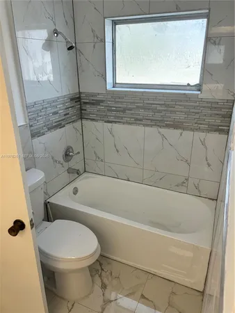 a bath room with a toilet and a bath tub