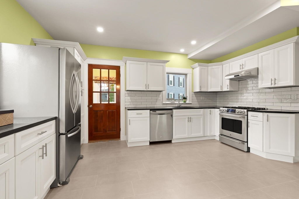 177 Nevada Street Newton, MA 02460 - Photo 19 of 40 a kitchen with granite countertop white cabinets and white stainless steel appliances