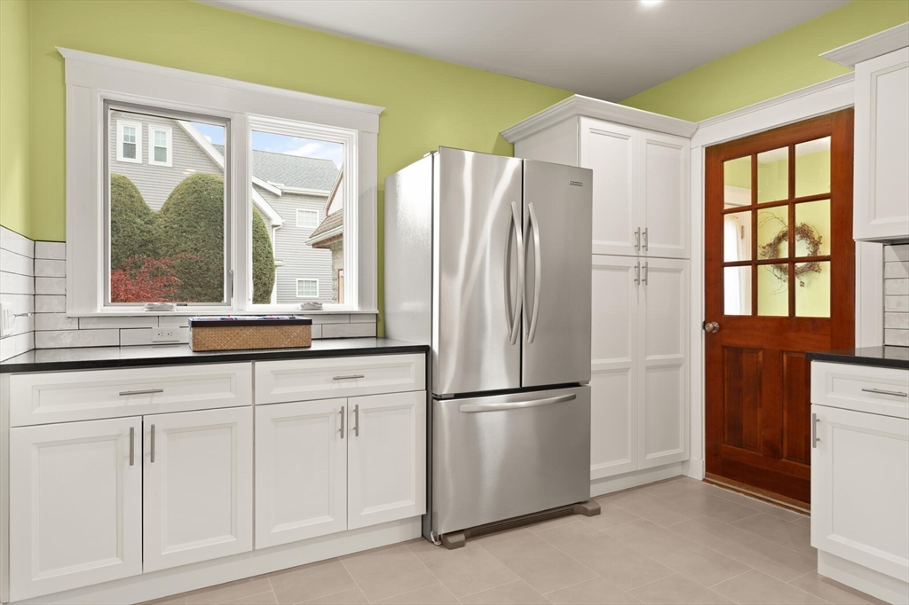 177 Nevada Street Newton, MA 02460 - Photo 20 of 40 a kitchen with white cabinets and a refrigerator