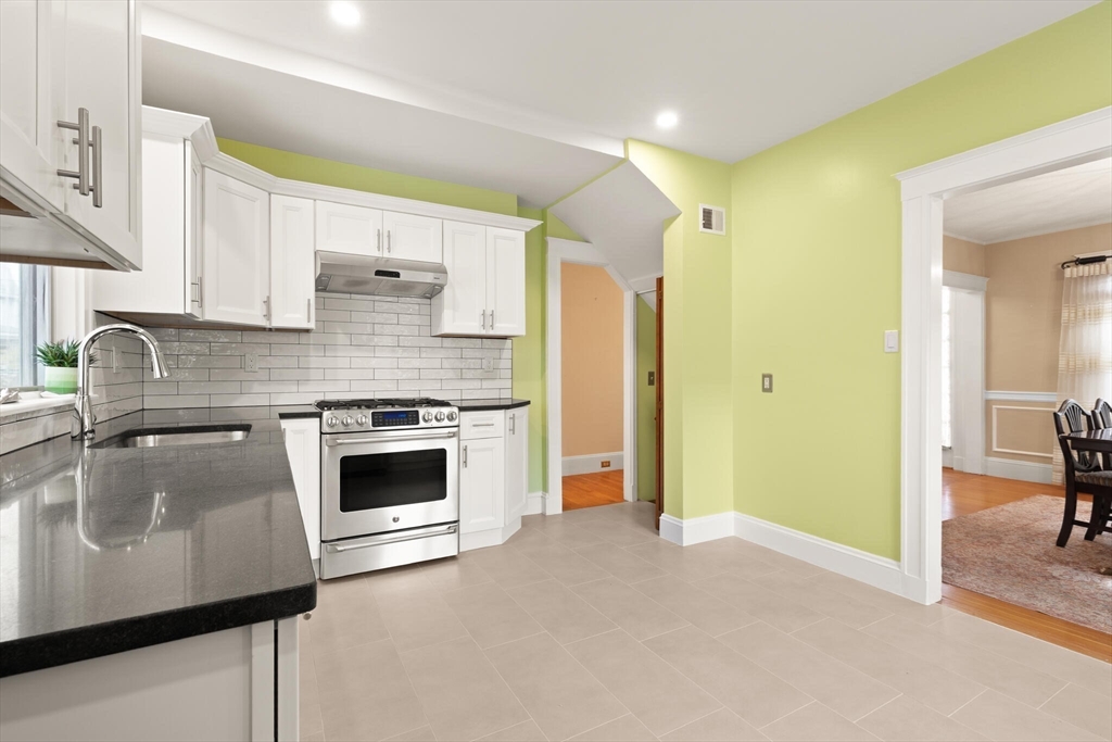 177 Nevada Street Newton, MA 02460 - Photo 21 of 40 a kitchen with granite countertop a stove and a sink