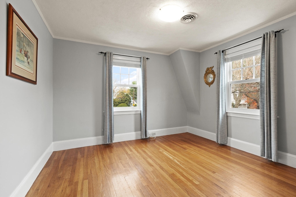 177 Nevada Street Newton, MA 02460 - Photo 25 of 40 an empty room with wooden floor and windows