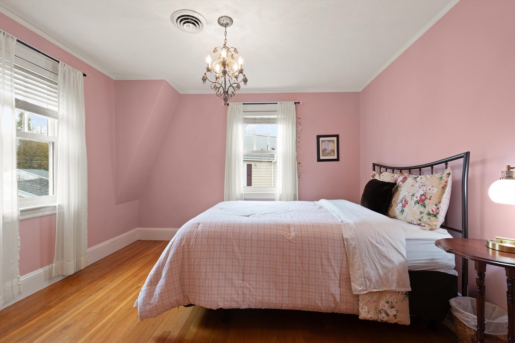 177 Nevada Street Newton, MA 02460 - Photo 26 of 40 a bedroom with a bed and a chandelier