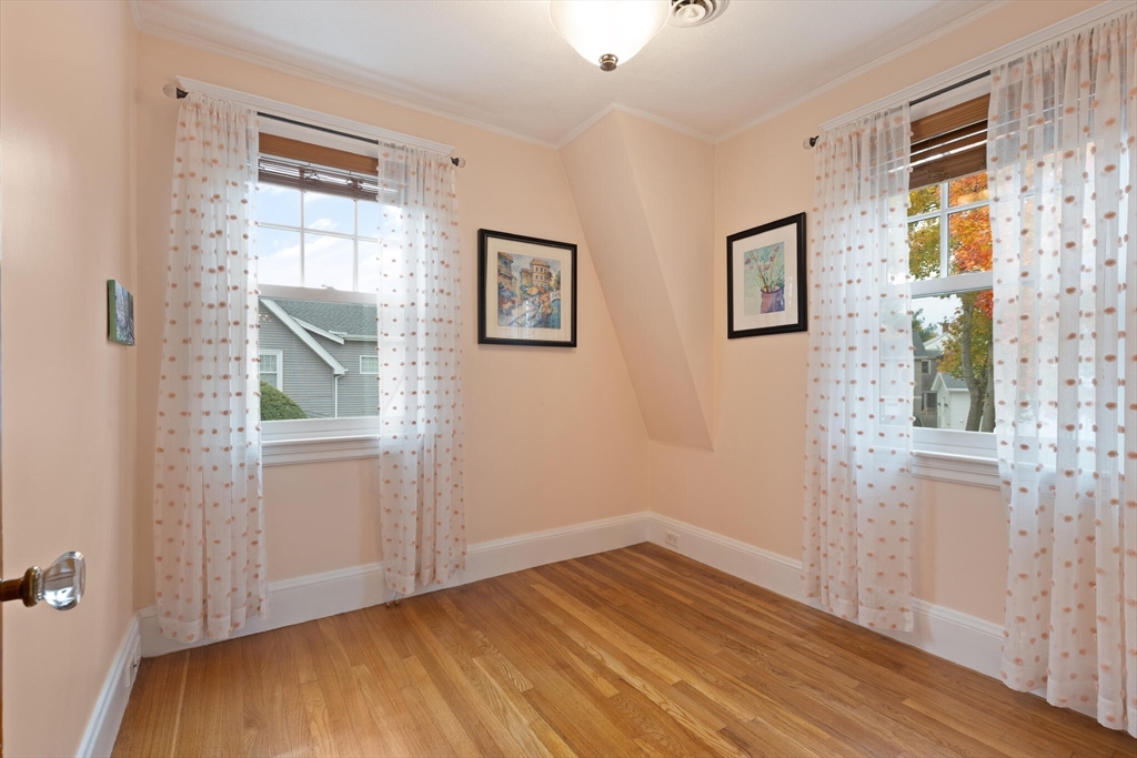 177 Nevada Street Newton, MA 02460 - Photo 27 of 40 a view of an empty room with wooden floor and a window