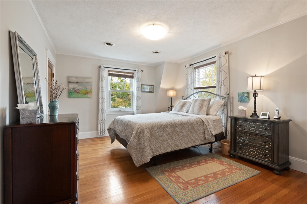 177 Nevada Street Newton, MA 02460 - Photo 28 of 40 a bedroom with a bed and wooden floor