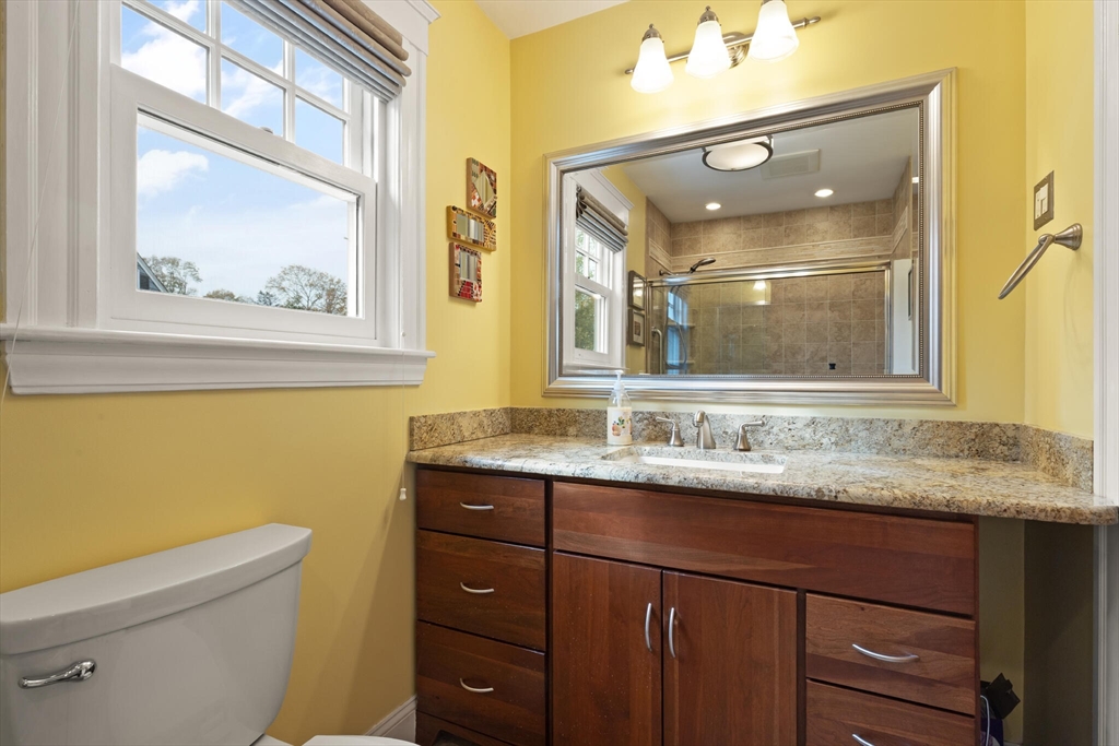 177 Nevada Street Newton, MA 02460 - Photo 35 of 40 a bathroom with a granite countertop toilet a sink and mirror
