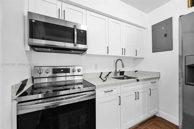 a kitchen with appliances a sink and cabinets