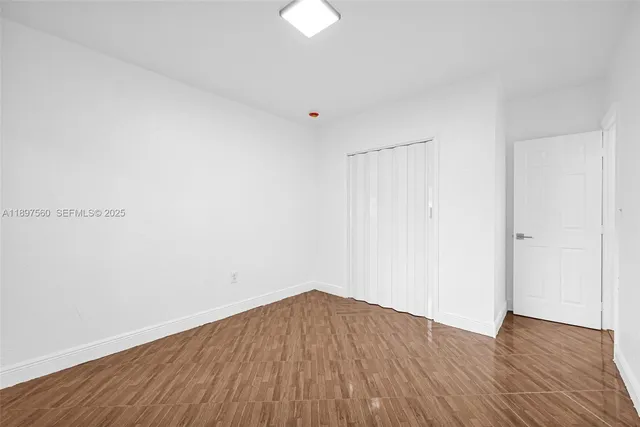 a view of a room with wooden floor and white walls