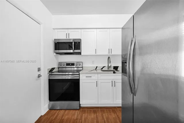 a kitchen with stainless steel appliances a stove microwave and refrigerator
