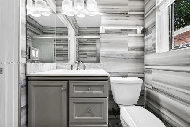 a bathroom with a toilet sink and mirror