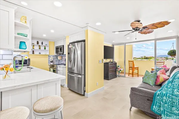 a kitchen with stainless steel appliances a refrigerator and a couch