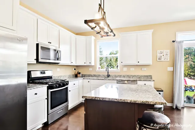 a kitchen with granite countertop a sink stainless steel appliances and cabinets