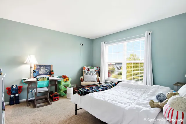 a bedroom with a bed a table and a window