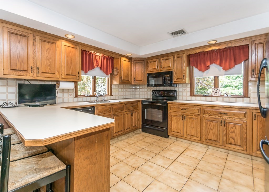 35 Woodchester Road Waltham, MA 02451 - Photo 4 of 39 a kitchen with stainless steel appliances granite countertop a stove a sink and a microwave