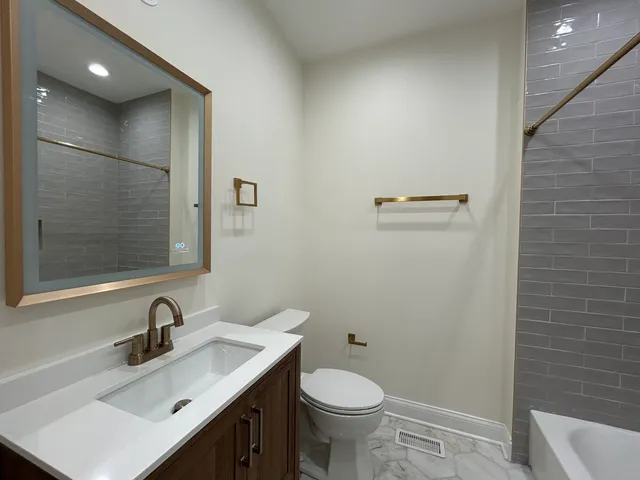 a bathroom with a sink toilet and a mirror