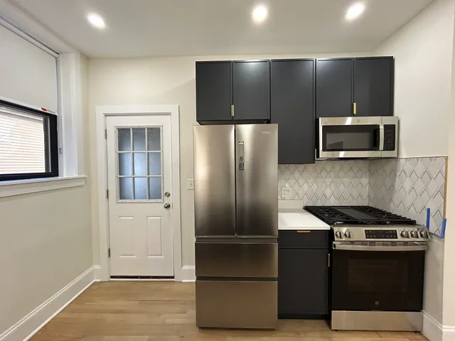 a metallic refrigerator freezer sitting in a kitchen