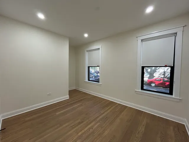 an empty room with wooden floor and painting on the wall