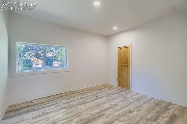 a view of empty room with wooden floor