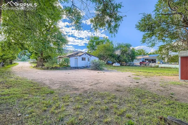 a view of backyard of house with green space