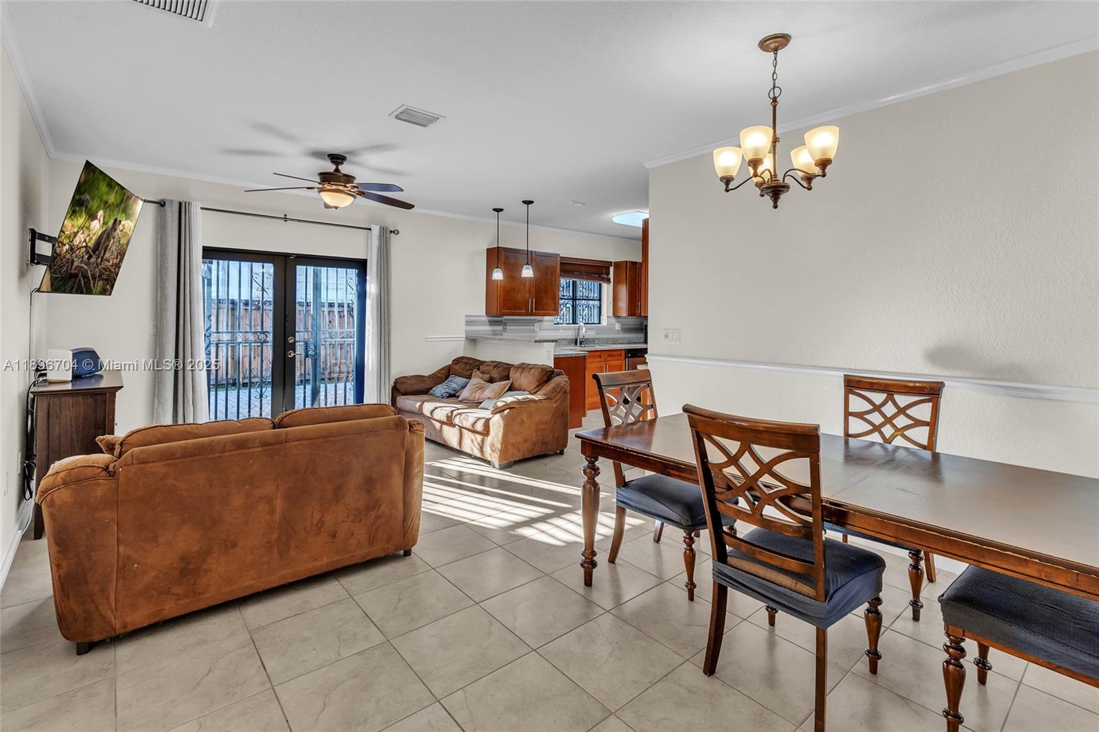 27109 Southwest 133rd Court Homestead, FL 33032 - Photo 17 of 48 a living room with furniture a chandelier and a flat screen tv